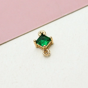 Close-up of a square green zircon connector with gold-plated edges for DIY jewelry making