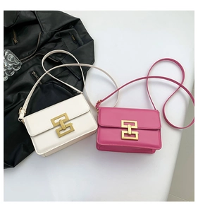 Close-up of stylish white and pink flap crossbody bags with golden H-shaped buckles