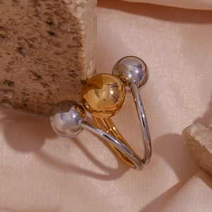 Detailed shot of two-tone triple ball ring on stone with silk background