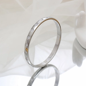 Polished silver titanium steel bangle with sparkling embedded crystals on mirror surface