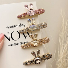 Close-up of four rhinestone rabbit ear hair clips in pink silver gold and grey colors