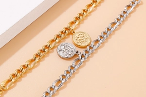Detailed macro view of gold and silver rope chain bracelets with tree of life coin charms