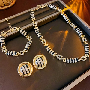 Detailed view of luxury gold jewelry set with black stripes and sparkling crystals