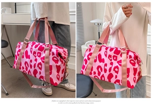 Detail of pink leopard print travel duffel bag with gold hardware and shoulder strap