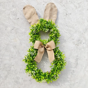 Détail de couronne de Pâques lapin avec verdure, oreilles en toile et un nœud rustique
