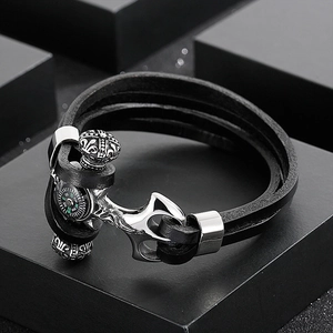 Detail view of leather wrap bracelet featuring a silver anchor clasp and mini compass