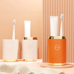 Portable fluted toothbrush holder cup set with gold trim in white and orange