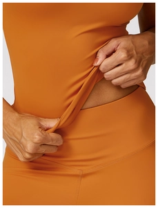 Close-up of high-elasticity orange yoga fabric showing stretch and material texture