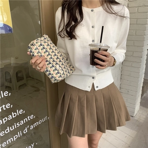 Trousse à maquillage fleurie associée à un cardigan blanc et une jupe plissée marron