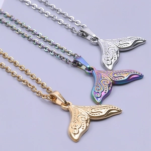 Detailed view of three stainless steel whale tail necklaces in gold, silver, and rainbow finishes