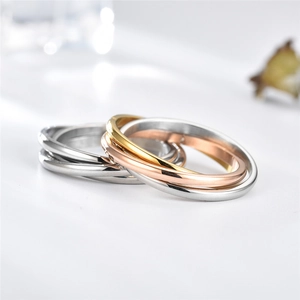 Detailed close-up of interlocking polished steel rings in silver, gold, and rose gold
