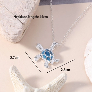 Detailed view of silver sea turtle pendant with blue resin shell and size annotations