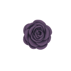 Macro detail of purple handmade satin fabric camellia flower accessory with textured petals