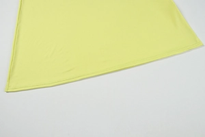 Gros plan détaillé de l'ourlet de la robe en tricot jaune clair avec couture double aiguille