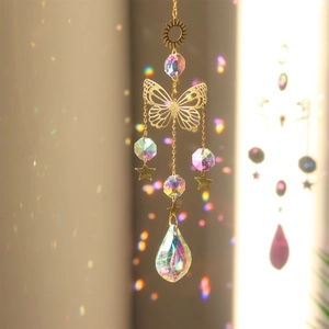 Detail of crystal suncatcher casting colorful light refraction through gold metal sun and stars