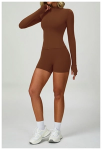 Full body shot of a chocolate brown yoga set with zip-up top and high waist biker shorts