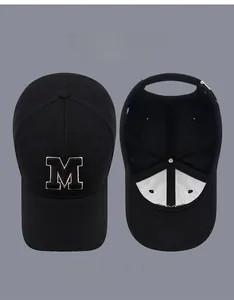 Detail view of black baseball cap with M embroidery and internal structure with vent holes