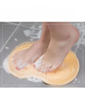 Macro detail of yellow silicone foot scrubber with foam in a shower setting