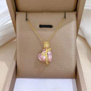 Detail of pink heart crystal necklace with golden rose and sparkling white diamonds