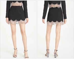 Detail of black skirt suit with wave edges and silver chain fringe tassels