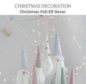 Macro view of pastel felt Christmas gnomes hanging with soft bokeh lighting