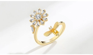 Close-up of golden spinning fidget ring with crystal bee and flower design detail