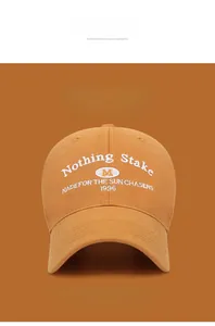 Close-up of embroidered baseball cap with 'Nothing Stake' text and sun chaser logo