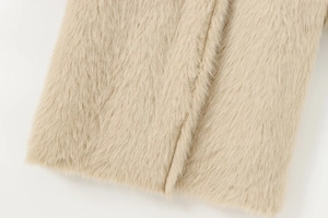 Macro shot of faux fur texture and beige plush fibers on a long reversible coat