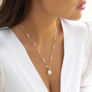 Gold chain body necklace with faux pearls and baroque pearl pendant on model