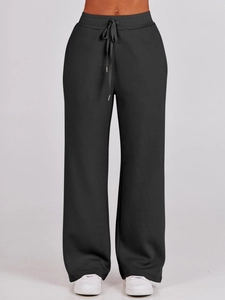 Close-up of black high-waisted wide-leg sweatpants with adjustable drawstring detail