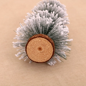 Macro detail of artificial cedar Christmas tree with snow effect on a wooden base