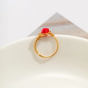 Detailed macro view of handmade gold wire wrapped ring with irregular red stone
