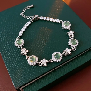 Détail d'un bracelet en argent avec pierres fleurs vertes et accents d'étoiles sur cuir