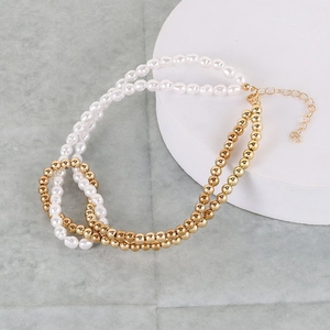 Close-up of double-layer necklace with white faux pearls and gold beads on marble surface