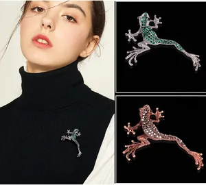 Detail view of frog brooches in green and brown crystal showing intricate rhinestone setting