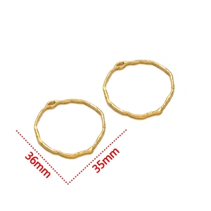 Macro detail of irregular gold finish pendants with textured surface and size markings