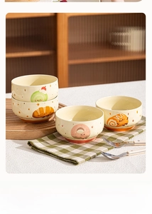 Detail of four ceramic bowls with cute cartoon dessert patterns and orange trim