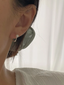 Close-up of a 925 silver pearl hoop earring worn by a model in a minimalist style