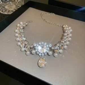 Luxe teardrop crystal and pearl floral choker necklace shown on elegant jewelry box display