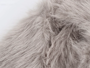 Macro shot of soft faux fur texture on a long faux fur coat with white background