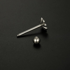 Silver stainless steel tongue ring with floral design on a black matte background