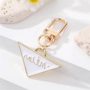Detail of a triangle enamel keychain with gold Helen lettering and lobster clasp
