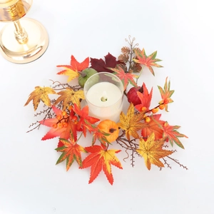 Detail of autumn candle ring with faux maple leaves, mini pumpkins, and red berries decor