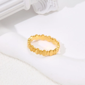 Macro detail of gold-plated oval linked ring with brushed metal texture and modern design