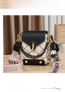 Détail du sac bandoulière avec chaîne dorée, sangle rose et joli charm en forme d'ours