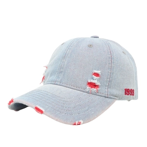 Vintage distressed blue denim baseball cap with 1999 red embroidery and ripped details