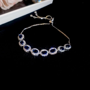 Vue macro du bracelet ajustable avec sept saphirs bleus ovales et un halo de zircones