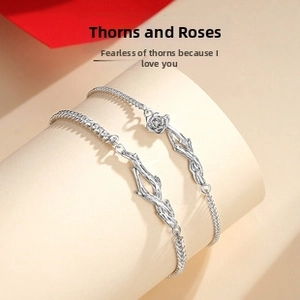 Close-up of thorn and rose couple bracelets in silver metal with detailed carving