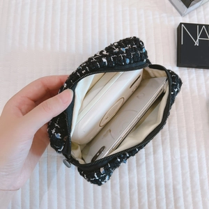 Tweed cosmetic bag with black zipper showing storage space for phone and power bank