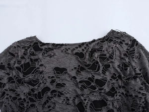 Gros plan du col et de la texture déchirée sur ce haut gris à manches longues